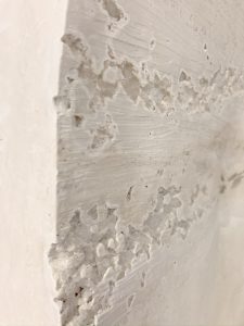 A close up of a white plaster panels with salt crystals embedded